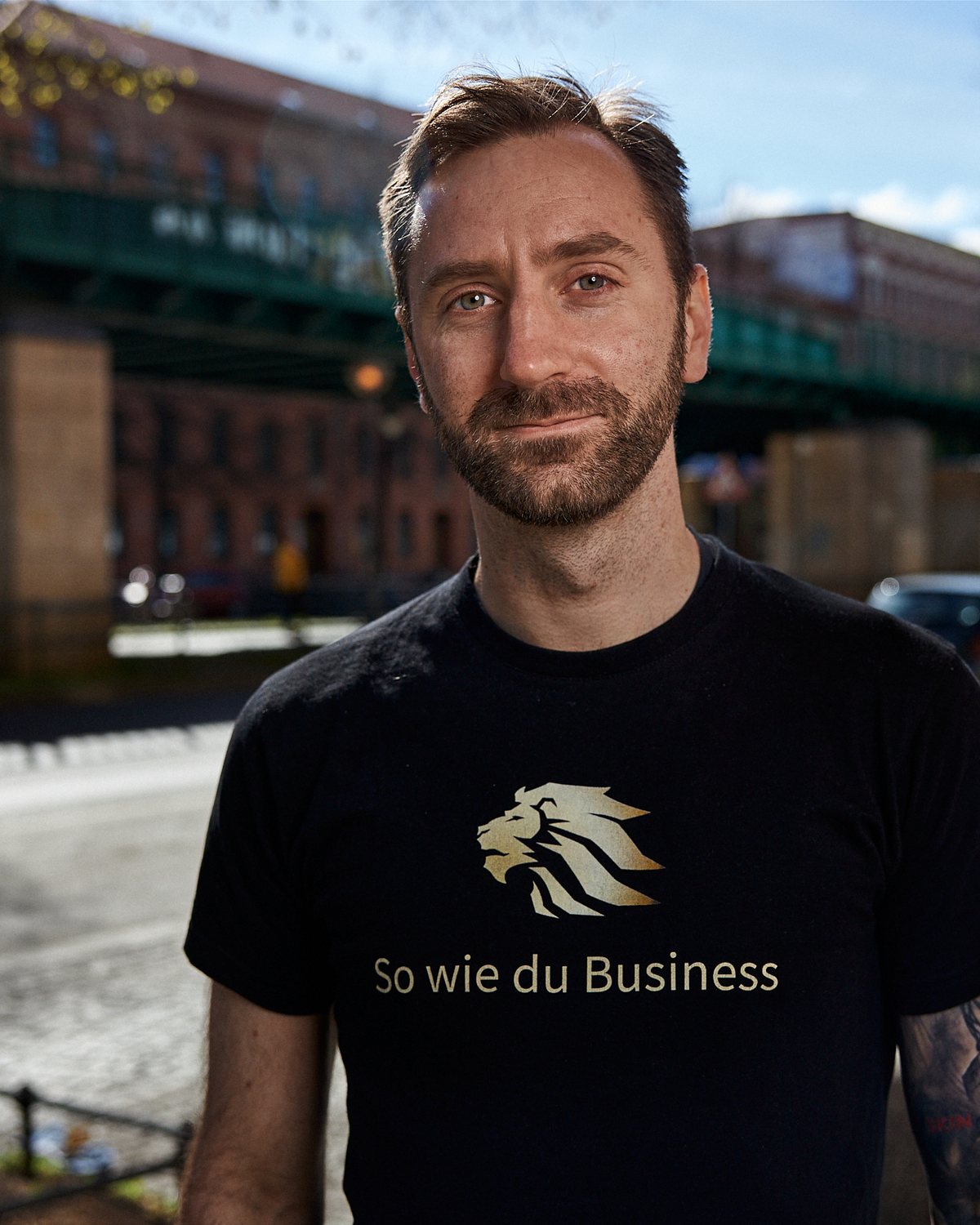 Dennis Herrmann, Business-Mentor, Portrait vor einer Berliner Hochbahn